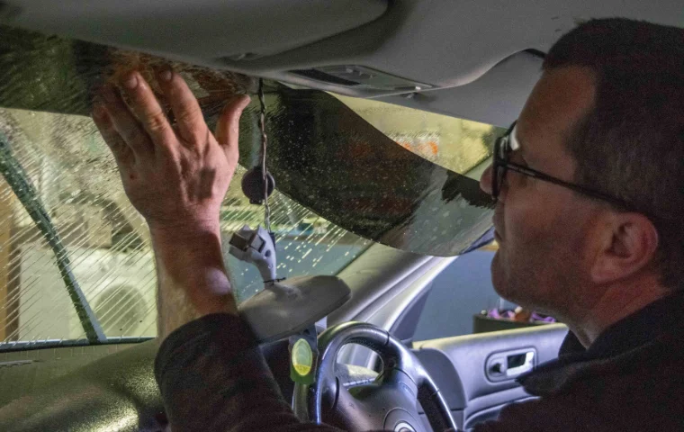 Ben Armstrong, Owner of South West Windscreens & Tint, installing a compliant tinted windscreen strip above the wiper sweep area in Busselton workshop.