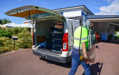 Ben owner of South West Windscreens & Tint unloading replacement windscreen glass from the mobile service van at a residential property in South West WA.